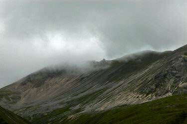 Picture of a mountain ridge with clouds just touching it