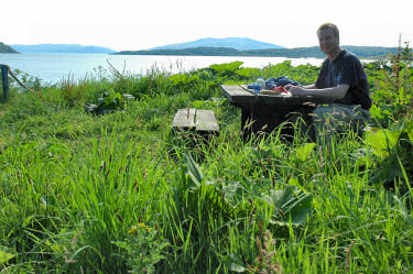 Picture of Armin sitting at a table at the picnic spot overlooking Asknish Bay