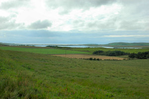 Picture of a loch (lake) with the sun breaking through clouds above