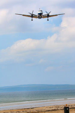Picture of a plane coming in to land over a bay