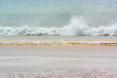 Picture of a small wave breaking on a beach